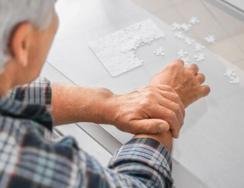 putting puzzles, a man holds his hand